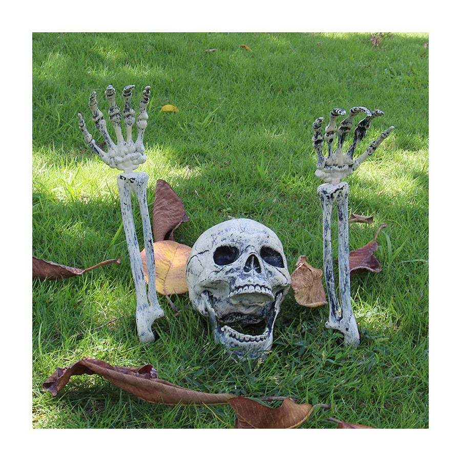 A skeleton skull and two hands staked into a lawn as if buried