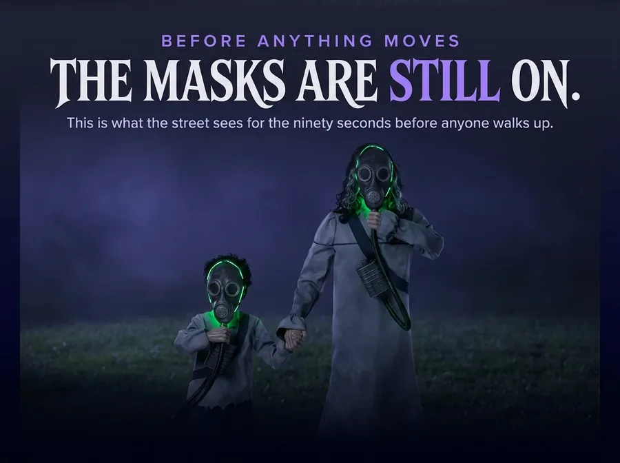 Night close-up of both figures with the gas masks held over their faces, only a green line escaping at the edges.